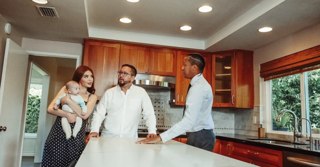 A young family tours a modern kitchen guided by a real estate agent.